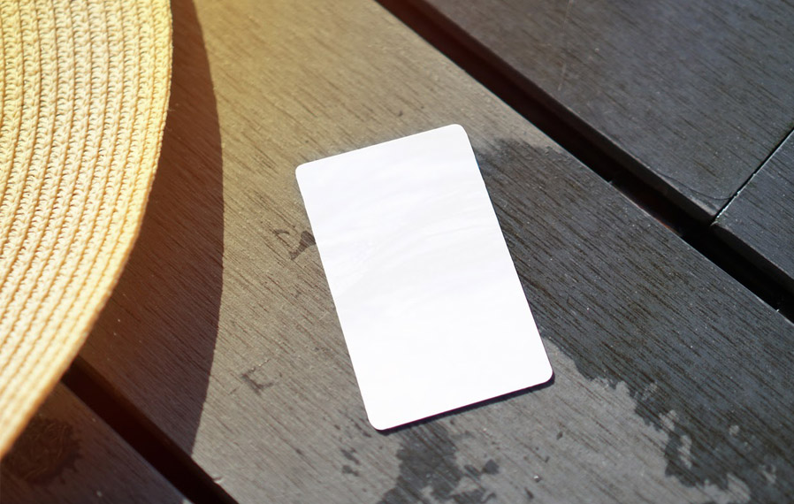 Don't forget your pool pass to to take a refreshing swim at The Waverley Apartments. Summer hat and key card on a deck floor.